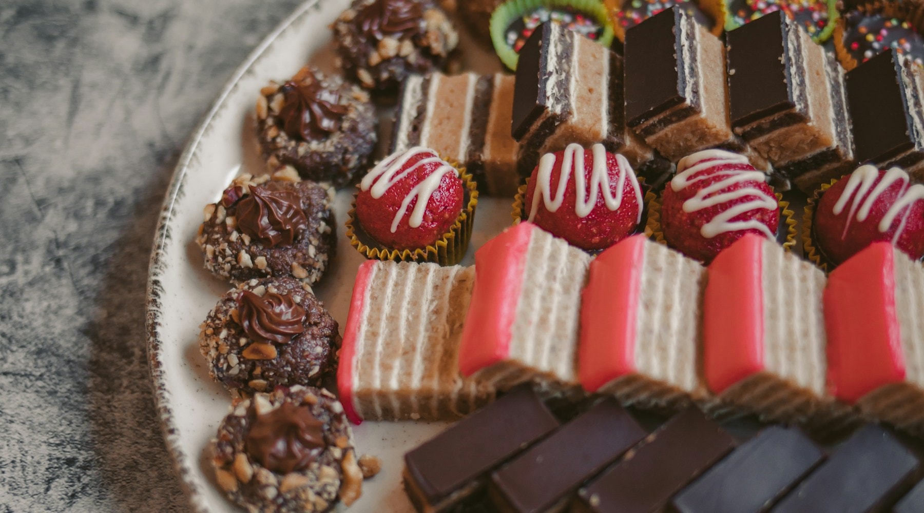 Assorted artisan chocolate truffles and pastries on a ceramic plate
