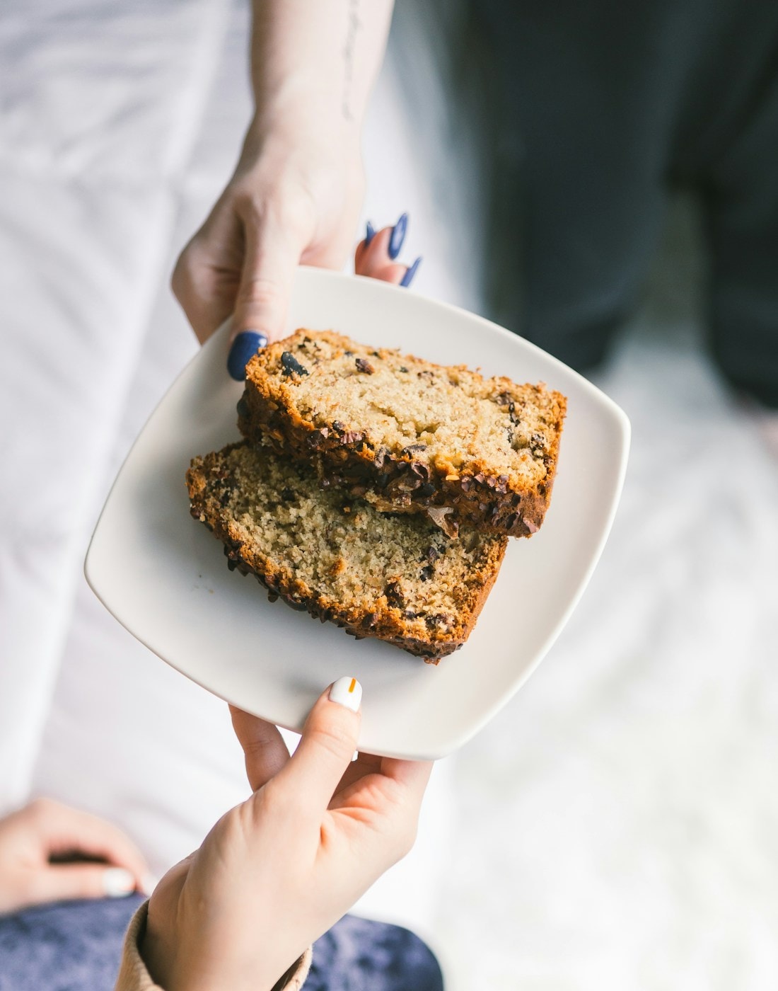 Hands sharing a plate of dessert — the spirit of Ramadan gifting